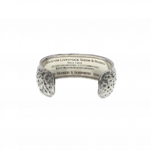 The inside engraving of the Clint Orms Houston Rodeo silver cuff, engraved with "Houston Livestock Show & Rodeo, Since 1932, 35,000 volunteers, 110 committees, $600 million in scholarships."