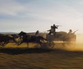 A horse carriage pulling gun-wielding men races across a plain in "Horizon: Part 1."